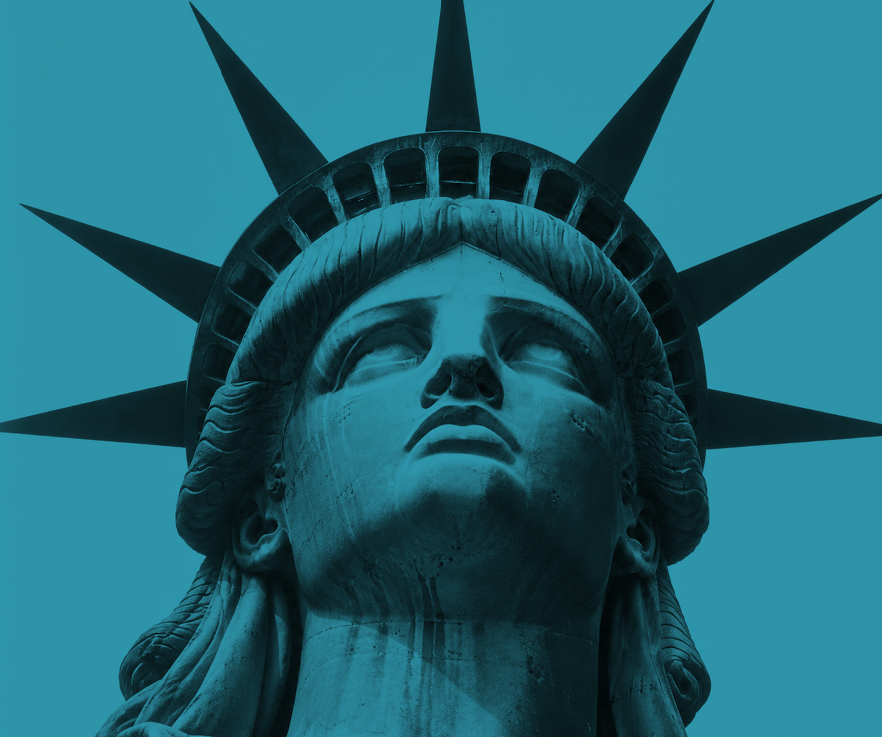 The crown of the Statue of Liberty against a teal sky